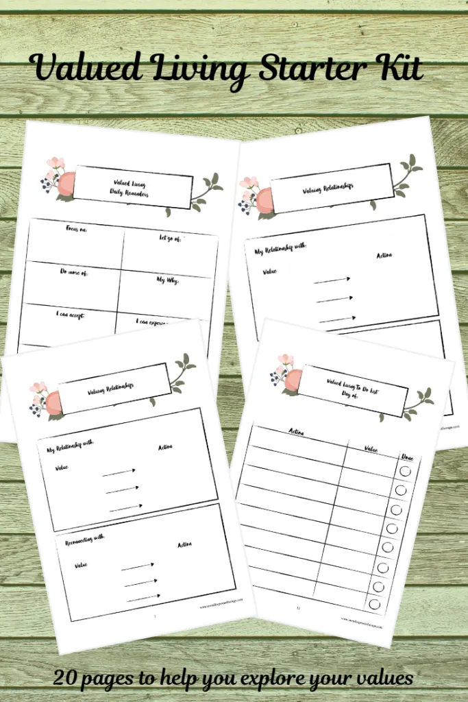 Printed worksheets titled "Valued Living Starter Kit" arranged on a green wooden surface with decorative floral elements