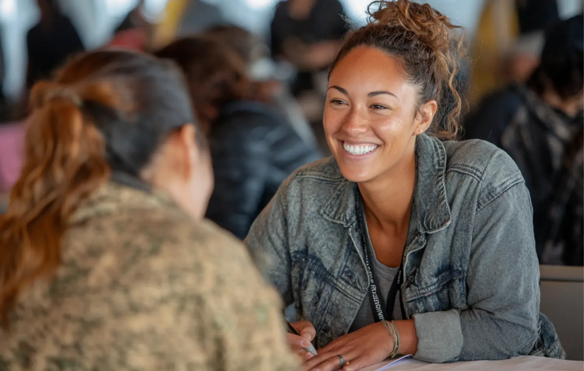 Two women share a close conversation in a crowded cafe
