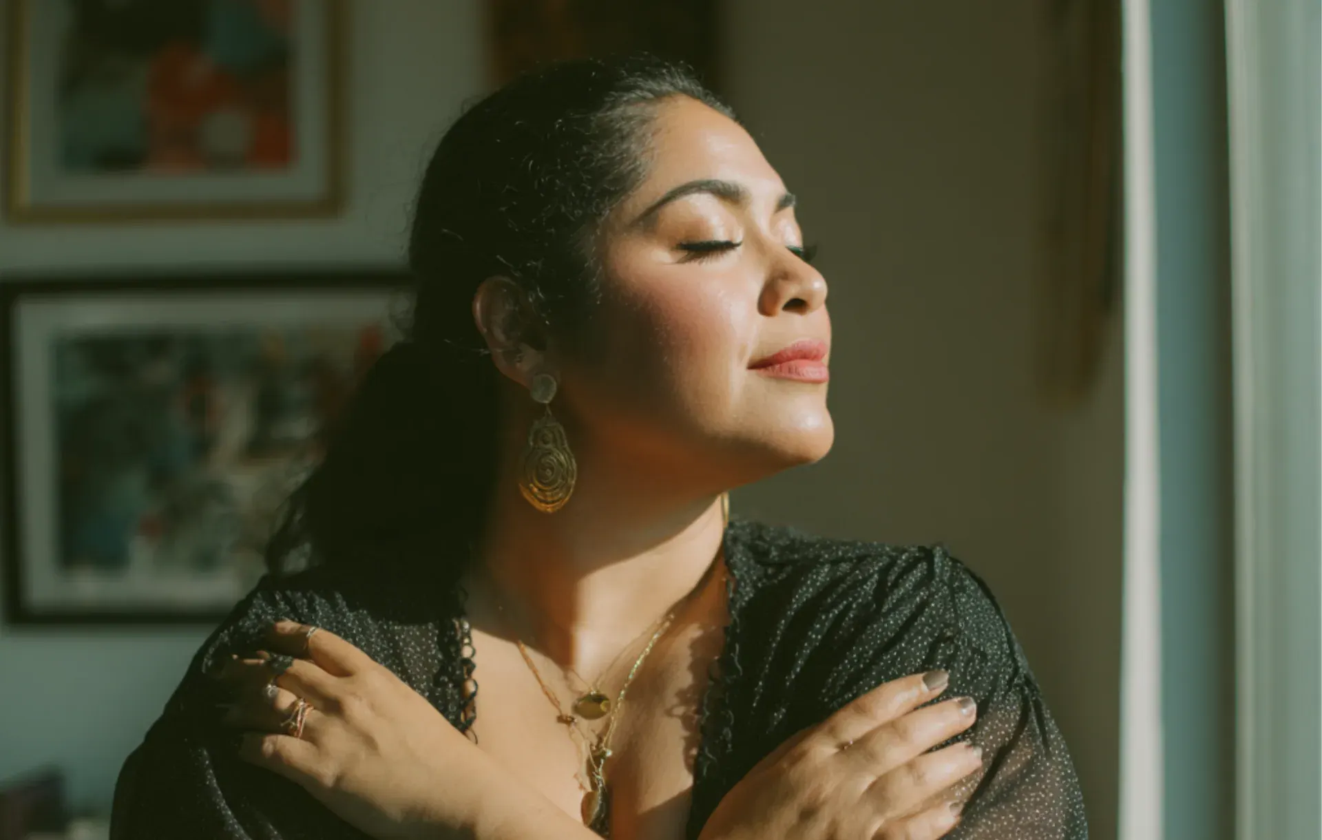 A woman in profile closes her eyes in warm afternoon sunlight